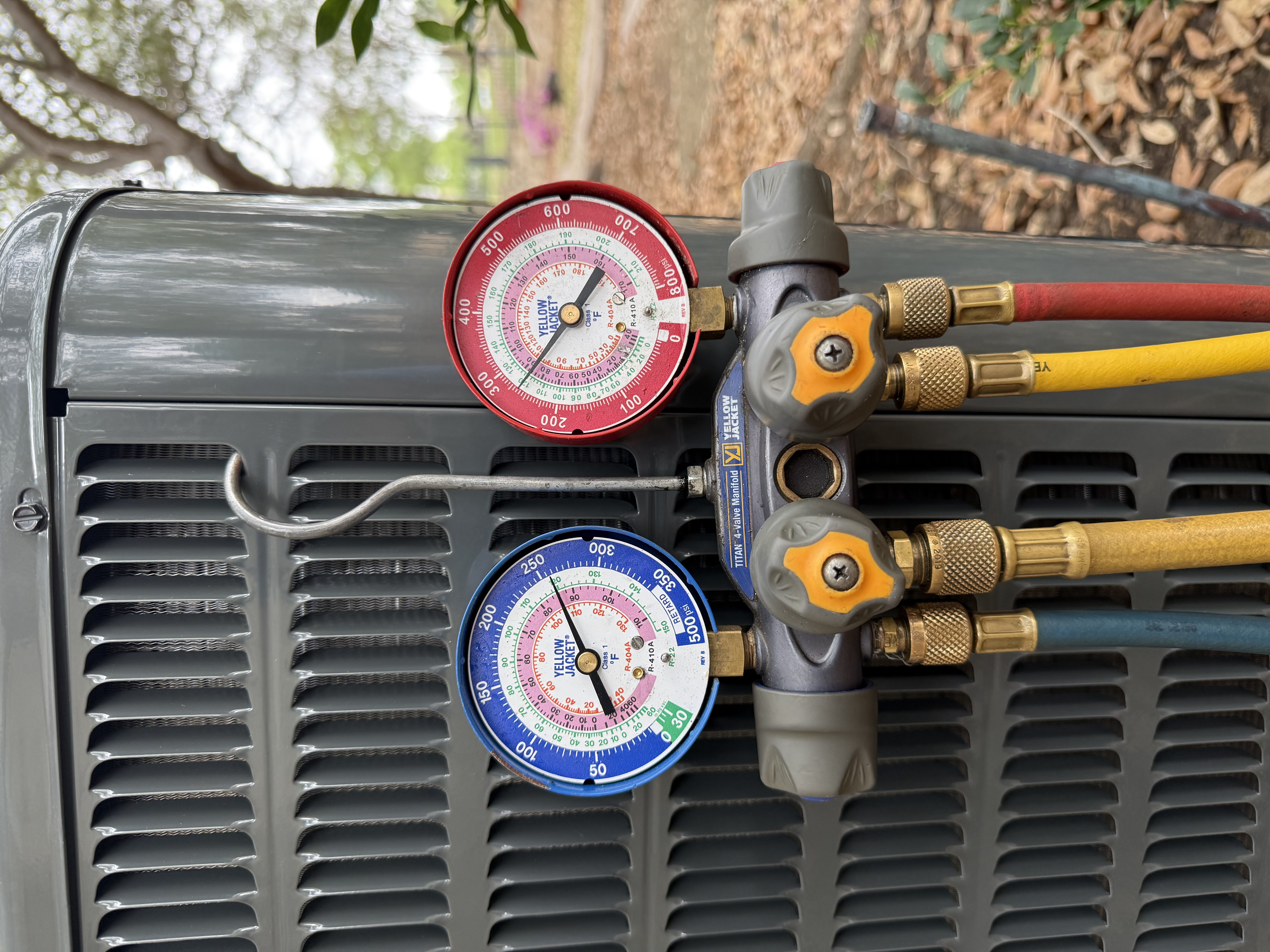 HVAC technician performing AC diagnostic with refrigerant gauges in San Antonio